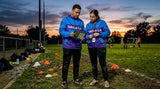 Coaches in custom team apparel by soccer field