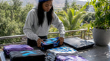 Woman sorting custom printed apparel in home studio