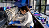 Apparel specialist operating embroidery machine
