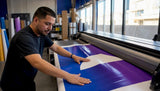 Hands adjusting vinyl banner at print shop