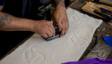 Hands embossing and debossing fabric close-up