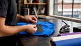Hands attaching custom hang tag to garment