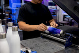 Hands pressing print onto stainless water bottle