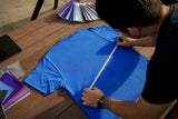 Hands measuring t-shirt back print area