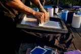 Hands screen printing white underbase on dark shirt