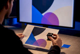 Prepress designer comparing vector artwork and proof