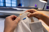 Hands inspecting anonymous apparel label sample