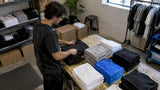Creator sorting folded shirts into run-size piles