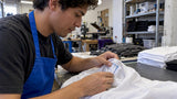 Worker inspecting sewn-in apparel tracking label