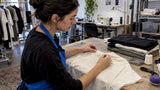 Maker positioning a label at a shirt neckline