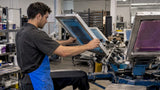 Operator aligning screens on a production press