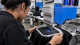 Embroidery machine stitching a garment logo