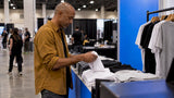 Organizer counts shirts at an event merch booth